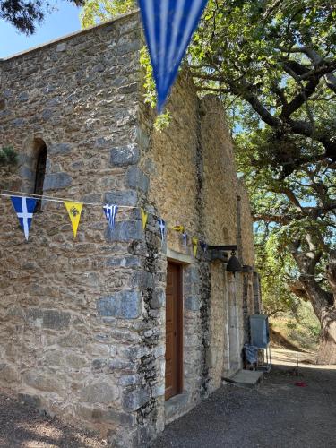a stone building with flags and a door at Villa GIANNAKOS MINOAN HERSONISSOS in Kastéllion