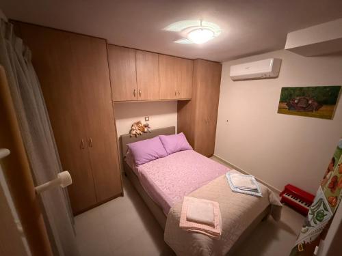 a small bedroom with a bed and a cabinet at Villa GIANNAKOS MINOAN HERSONISSOS in Kastéllion