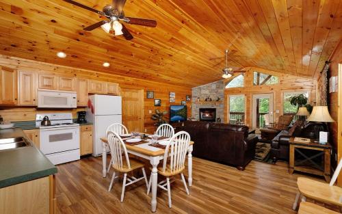 a kitchen and living room with a table and chairs at Dogwood Acres in Pigeon Forge