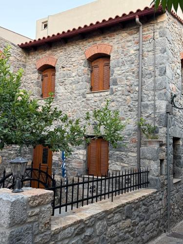 a stone house with brown windows and a fence at Villa GIANNAKOS MINOAN HERSONISSOS in Kastéllion
