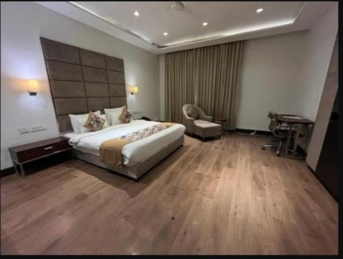 a hotel room with a large bed and a desk at Hotel Golden Palm in Gurdāspur