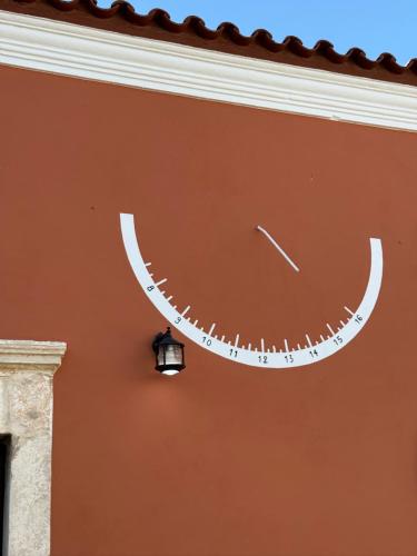 a clock on the side of a wall with a light at Villa GIANNAKOS MINOAN HERSONISSOS in Kastéllion
