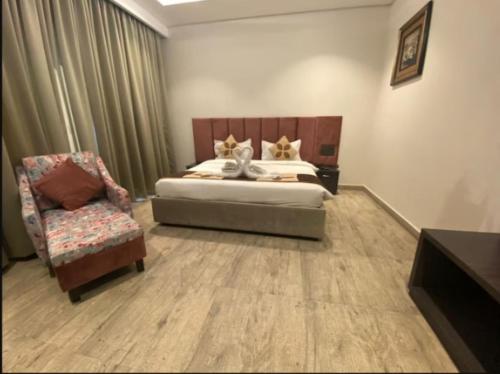 a bedroom with a bed and a chair at Hotel Golden Palm in Gurdāspur