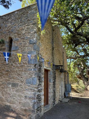 a stone building with flags and a door at Villa GIANNAKOS MINOAN HERSONISSOS in Kastéllion