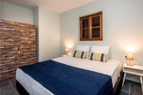a bedroom with a large bed with a wooden headboard at Kunuku Resort All Inclusive Curacao, Trademark by Wyndham in Willemstad