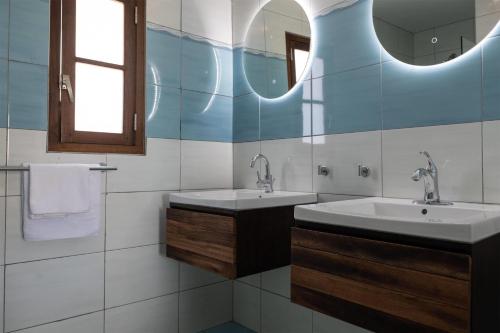 a bathroom with two sinks and a mirror at Kunuku Resort All Inclusive Curacao, Trademark by Wyndham in Willemstad