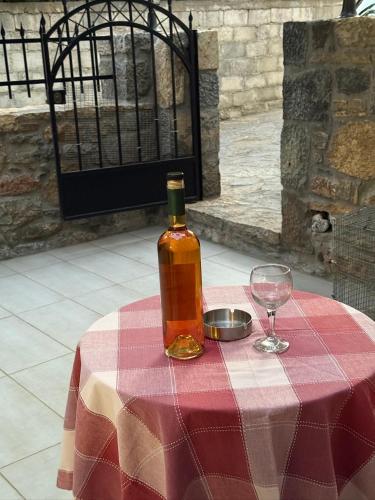 a bottle of alcohol sitting on a table with a wine glass at Villa GIANNAKOS MINOAN HERSONISSOS in Kastéllion