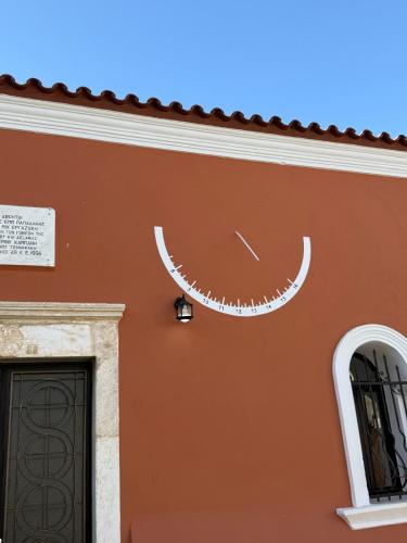 a building with a clock on the side of it at Villa GIANNAKOS MINOAN HERSONISSOS in Kastéllion