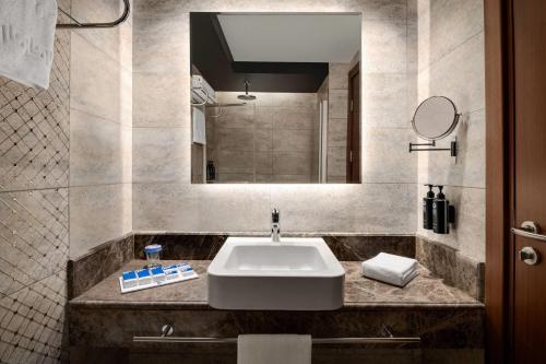 a bathroom with a sink and a mirror at TRYP by Wyndham Istanbul Maltepe in Istanbul