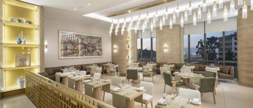 a restaurant with tables and chairs in a room at Hyatt Regency Izmir IstinyePark in Izmir