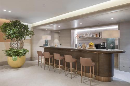 a bar in a room with a bunch of stools at Hyatt Regency Izmir IstinyePark in Izmir