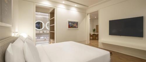 a bedroom with a bed and a flat screen tv at Hyatt Regency Izmir IstinyePark in Izmir