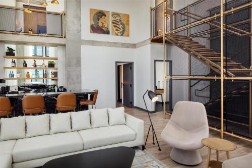 a living room with a white couch and a bar at Canopy By Hilton Nashville Downtown The Gulch in Nashville