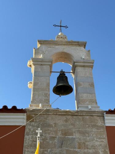 a bell on the side of a tower with a cross at Villa GIANNAKOS MINOAN HERSONISSOS in Kastéllion