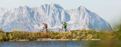 two people riding bikes over a body of water at Apartment Sunnyside Premium by Alpine Host Helpers in Kirchberg in Tirol
