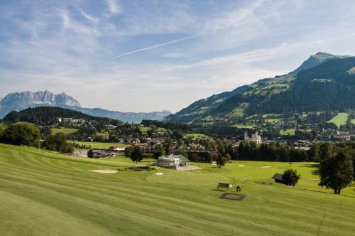 a green field with mountains in the background at Apartment Sunnyside Premium by Alpine Host Helpers in Kirchberg in Tirol