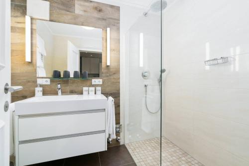a bathroom with a white sink and a shower at Kitz-Heart Apartments by Alpine Host Helpers in Kitzbühel