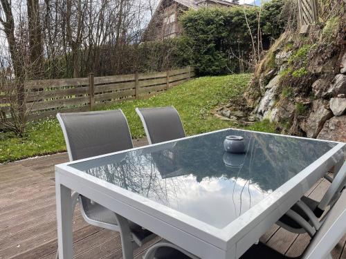a glass table with chairs and a bowl on top of it at Kitz-Heart Apartments by Alpine Host Helpers in Kitzbühel