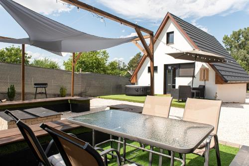 a patio with a table and chairs and a house at PilisRelax-Stílusos Vendèghàz in Pilismarót