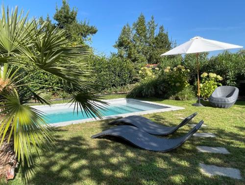 a black sculpture sitting in the grass next to a swimming pool at Les Hortensias in Espoey