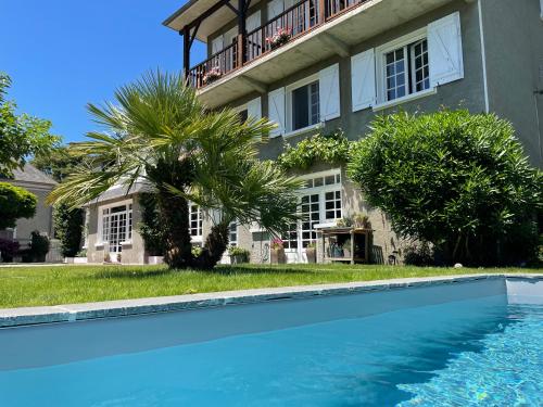 a house with a swimming pool in front of a building at Les Hortensias in Espoey