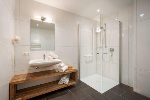 a bathroom with a sink and a shower at Premium Apartment Zentral by Alpine Host Helpers in Kirchberg in Tirol
