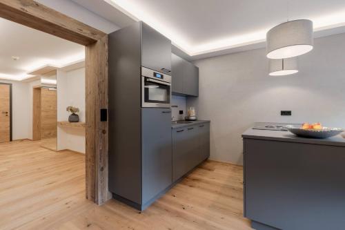 a kitchen with stainless steel appliances and a counter at Premium Apartment Zentral by Alpine Host Helpers in Kirchberg in Tirol