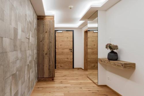 a hallway with wooden flooring and a wall with wooden doors at Premium Apartment Zentral by Alpine Host Helpers in Kirchberg in Tirol