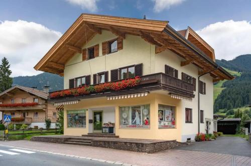 a large house with a wooden roof at Marias Alpen Apartment by Alpine Host Helpers in Brixen im Thale