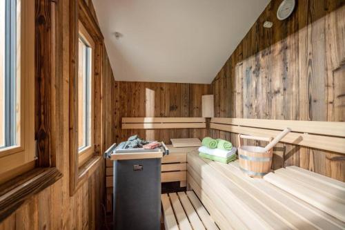 a sauna with wooden walls and a sink in a room at Marias Alpen Apartment by Alpine Host Helpers in Brixen im Thale