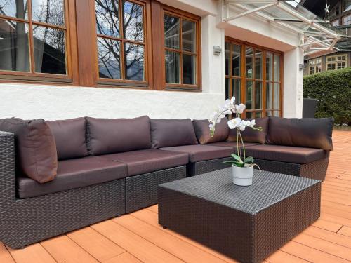 a brown couch sitting on a patio with a table at Kitz-Heart Apartments by Alpine Host Helpers in Kitzbühel