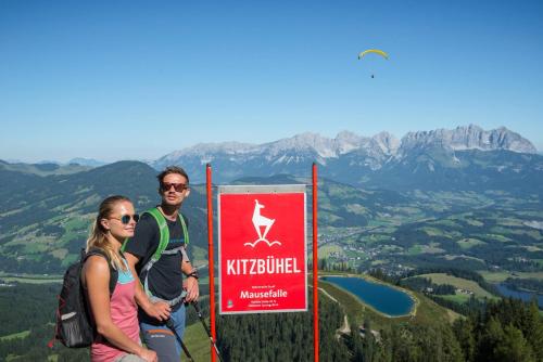 two people standing next to a sign at the top of a mountain at Kitz-Heart Apartments by Alpine Host Helpers in Kitzbühel
