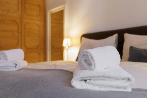 a pile of towels sitting on top of a bed at Kitz-Heart Apartments by Alpine Host Helpers in Kitzbühel