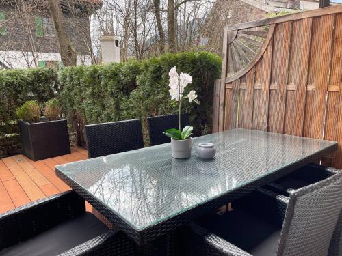a glass table with a potted plant on a patio at Kitz-Heart Apartments by Alpine Host Helpers in Kitzbühel