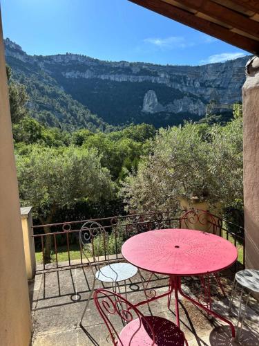 une table et des chaises roses sur un balcon avec vue dans l'établissement Villa Hélène in the heart of the center of Fontaine de Vaucluse, à Fontaine-de-Vaucluse