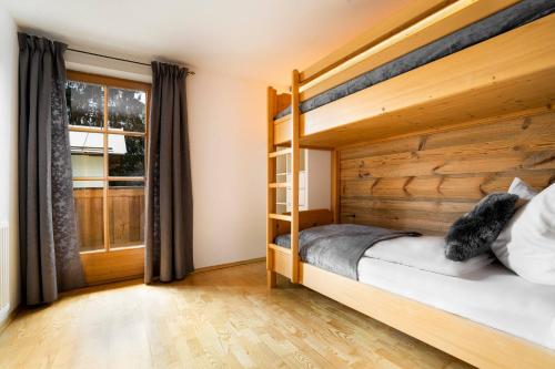 a bedroom with a bunk bed and a window at KitzAlps Apartments by Alpine Host Helpers in Kirchberg in Tirol