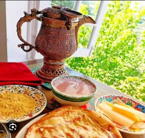 a table topped with plates of food and a vase at Gypsys Hostel in Srinagar