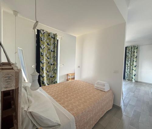 a bedroom with a bed and two windows at La Casa del Riccio in Tindari