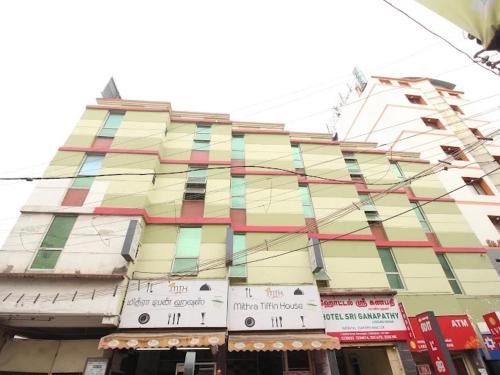 a tall building with colorful windows on a street at Sri Ganapathy Lodge in Coimbatore