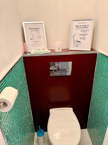 a small bathroom with a toilet with two signs on it at Pti Vélo in Annecy