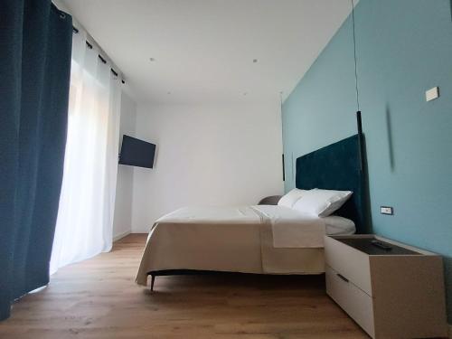 a bedroom with a bed and a large window at Le Chiavi di Polidoro in Aversa