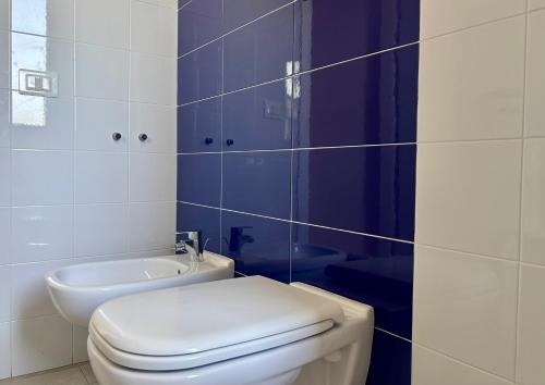 a white bathroom with a toilet and a sink at La Casa del Riccio in Tindari