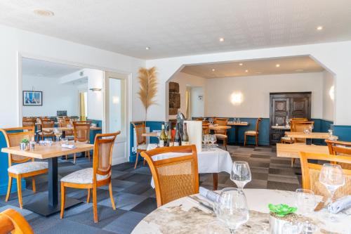 une salle à manger avec tables et chaises et un restaurant dans l'établissement Auberge Saint Thegonnec, à Saint-Thégonnec