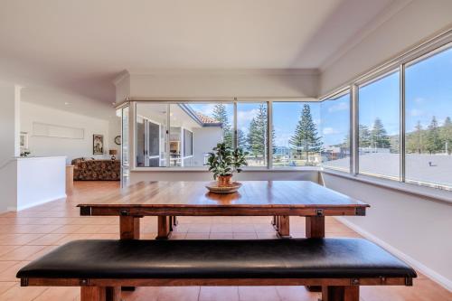 a living room with a wooden table and large windows at The Oceanside Stay by the BnB Collection in Albany