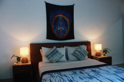 ein Schlafzimmer mit einem Bett mit zwei Lampen und einer Flagge in der Unterkunft ThanTha Ubud Villa in Ubud