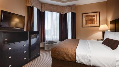 a hotel room with a bed and a flat screen tv at Best Western Dunkirk & Fredonia Inn in Dunkirk