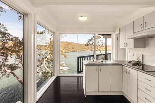a kitchen with a large window and a view of the water at Breathtaking Waterfront Retreat- Studio Apartment