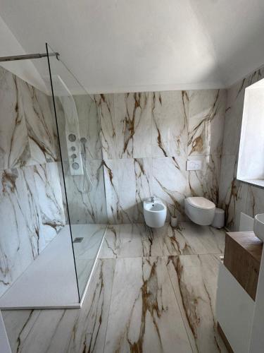 a marble bathroom with two sinks and two toilets at Residence Emma Lago di Viverone in Viverone