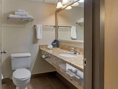 a bathroom with a toilet and a sink and a mirror at Best Western Plus Orillia Hotel in Orillia
