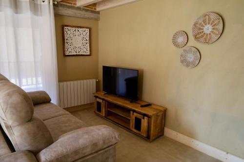 a living room with a couch and a television at Miradorio Rural Boutique Apto Tussio in Ruiloba